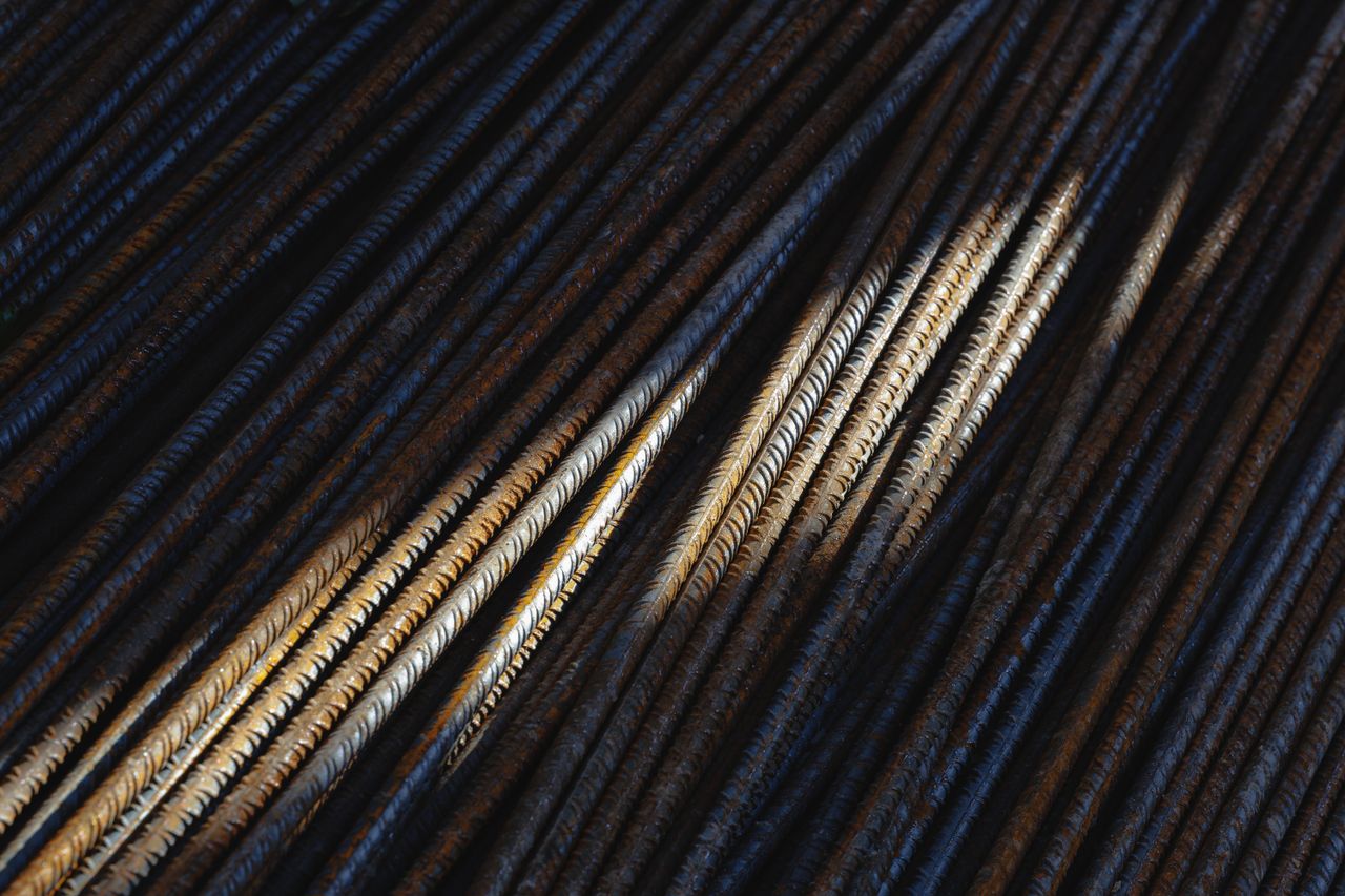 Artistic close-up of rusty steel rebars with dramatic lighting and texture.